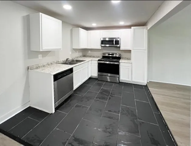 a kitchen with a sink a stove and cabinets