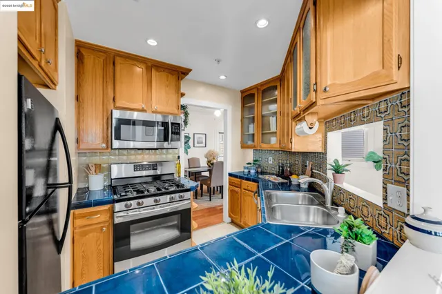 a kitchen with stainless steel appliances granite countertop a stove a sink and a refrigerator