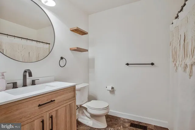 a bathroom with a toilet sink and mirror