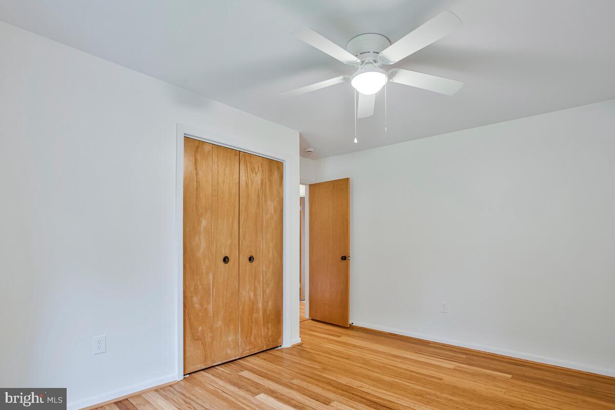 1428 Oak Bluff Road Edgewater, MD 21037 - Photo 27 of 43 an empty room with wooden floor and fan