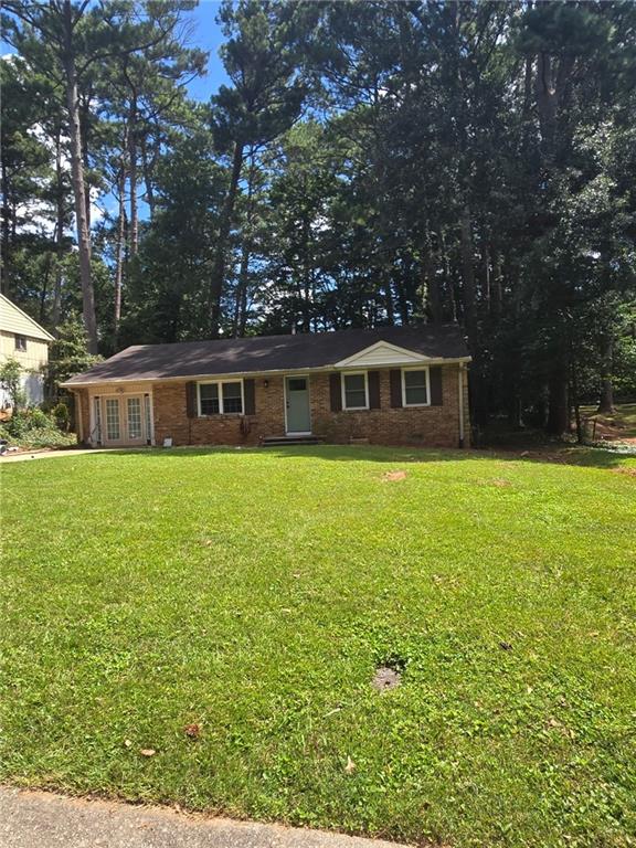 a view of house with yard outdoor seating and covered with trees