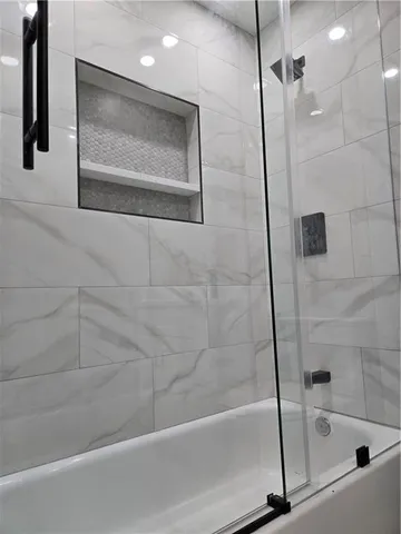 a bathroom with a shower and a bath tub