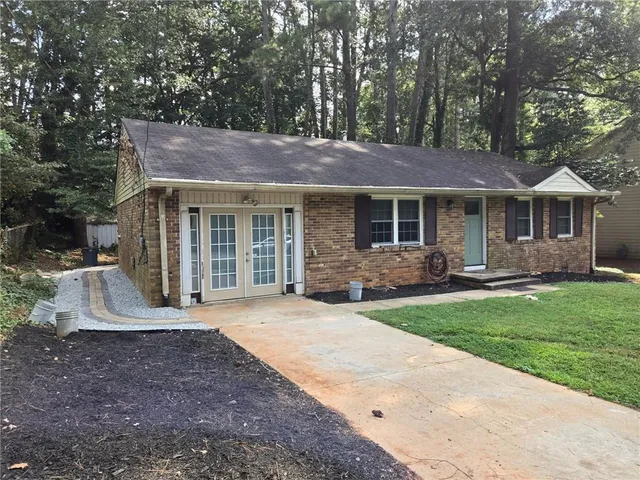 a front view of a house with a garden and yard