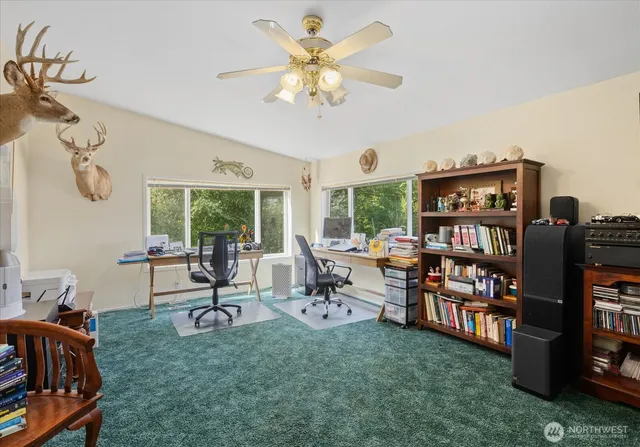 a living room with furniture and a bookshelf with wooden floor