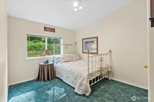 a bed sitting in a bedroom next to a window