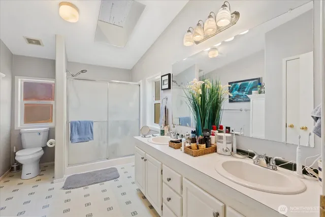 a bathroom with a sink a toilet and shower