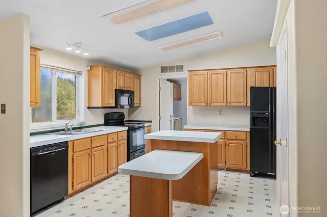 a kitchen with stainless steel appliances granite countertop a refrigerator a sink dishwasher a stove with wooden cabinets and floor