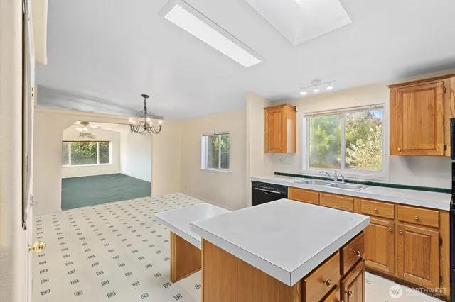 a bedroom with a large bed a chandelier and next to a window