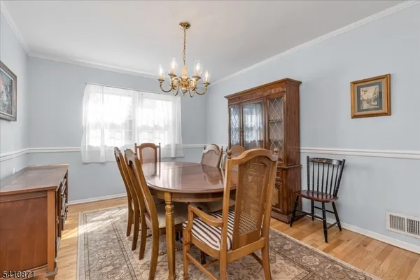 a dining room with furniture a chandelier and wooden floor