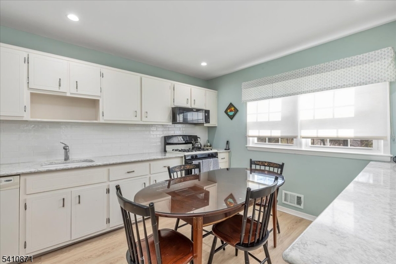 11 Dorr Road New Providence, NJ 07974 - Photo 8 of 28 a kitchen with stainless steel appliances granite countertop a sink a stove a table and chairs