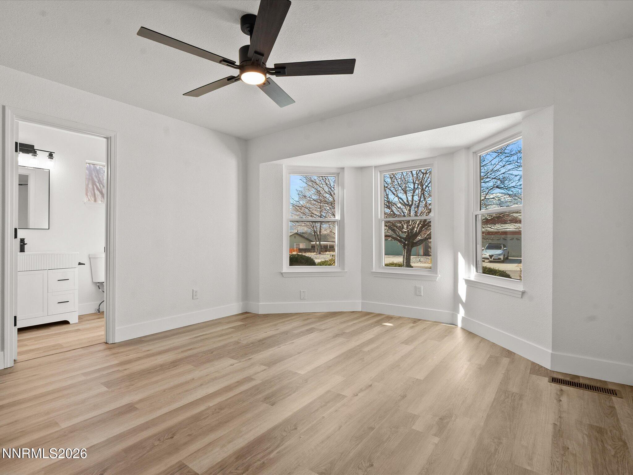 3549 Shadow Lane Carson City, NV 89705 - Photo 15 of 32 a view of an empty room with a window and wooden floor