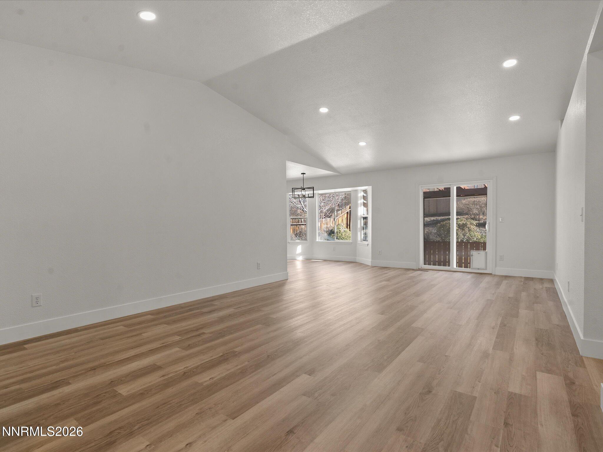 3549 Shadow Lane Carson City, NV 89705 - Photo 3 of 32 a view of an empty room with wooden floor and a window