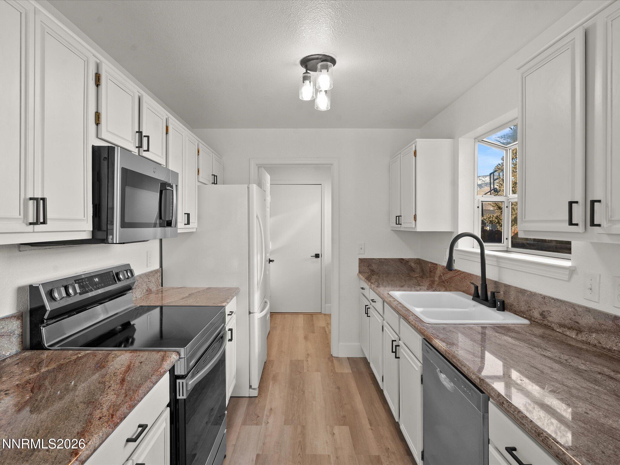 3549 Shadow Lane Carson City, NV 89705 - Photo 9 of 32 a kitchen with stainless steel appliances granite countertop a sink stove and refrigerator