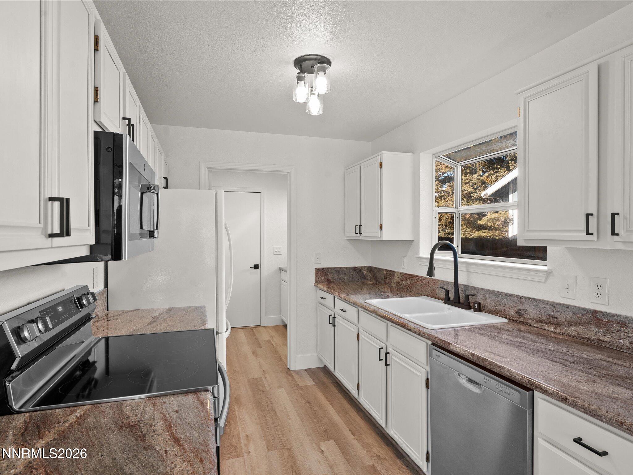 3549 Shadow Lane Carson City, NV 89705 - Photo 10 of 32 a kitchen with granite countertop a sink stove and cabinets