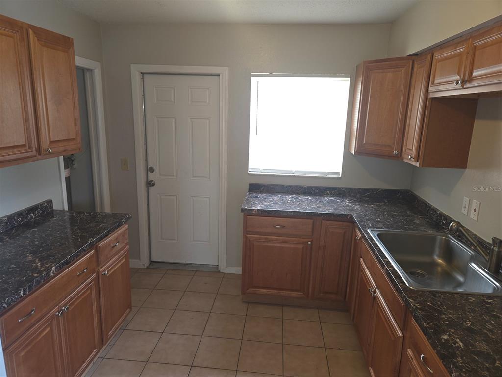 1741 Trotter Road, Unit A Largo, FL 33774 - Photo 3 of 9 a kitchen with a sink stove and cabinets
