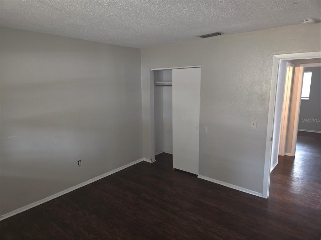1741 Trotter Road, Unit A Largo, FL 33774 - Photo 6 of 9 an empty room with wooden floor and closet