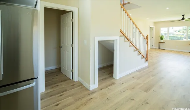 a view of a hallway with wooden floor and staircase