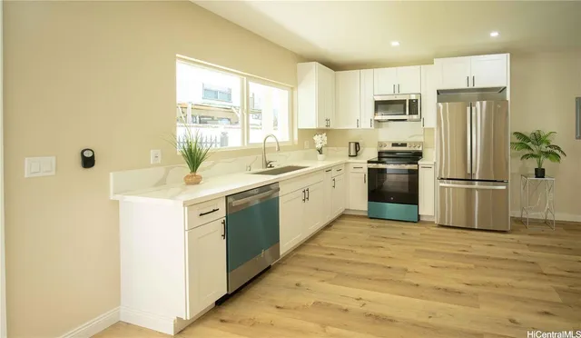 a kitchen with a sink appliances and cabinets