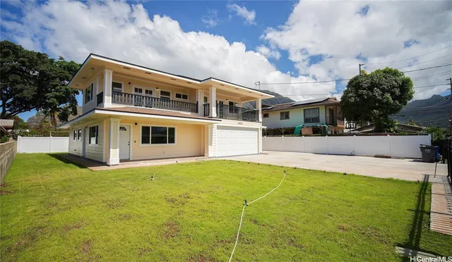 a front view of house with yard and trees in the background