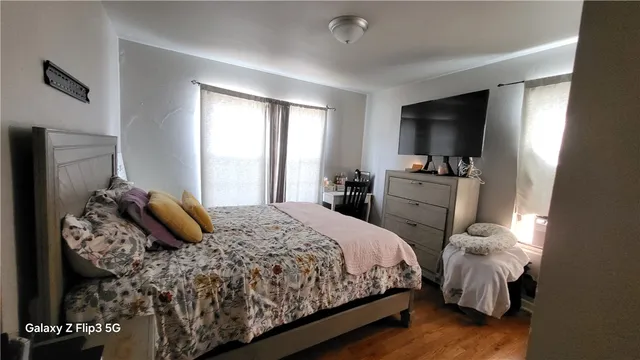 a bedroom with a bed and a flat tv screen on dresser