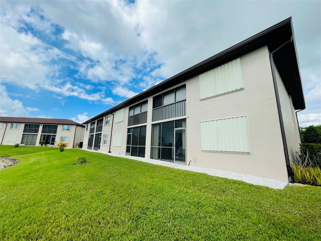 25100 Sandhill Boulevard, Unit Q201 Punta Gorda, FL 33983 - Photo 17 of 25 a view of a house with a big yard and large windows
