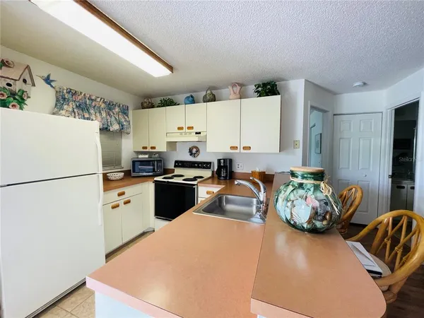a kitchen with stainless steel appliances a refrigerator sink and white cabinets