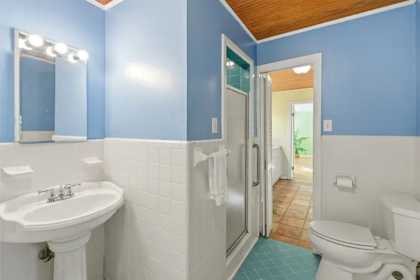 a bathroom with a sink a toilet and shower