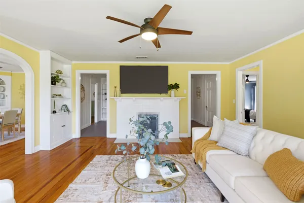 a living room with furniture and a wooden floor