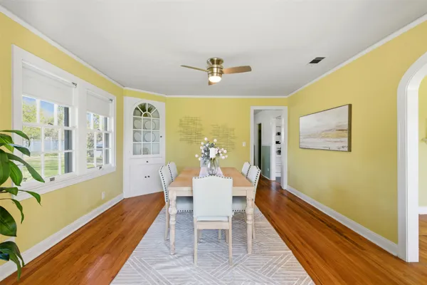 a dining room with furniture a chandelier and wooden floor