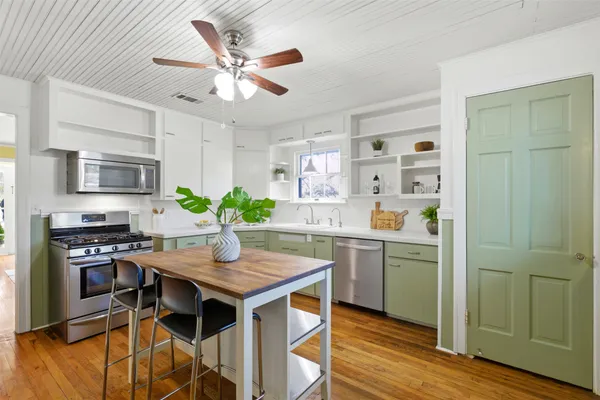 a kitchen with a table chairs refrigerator and cabinets
