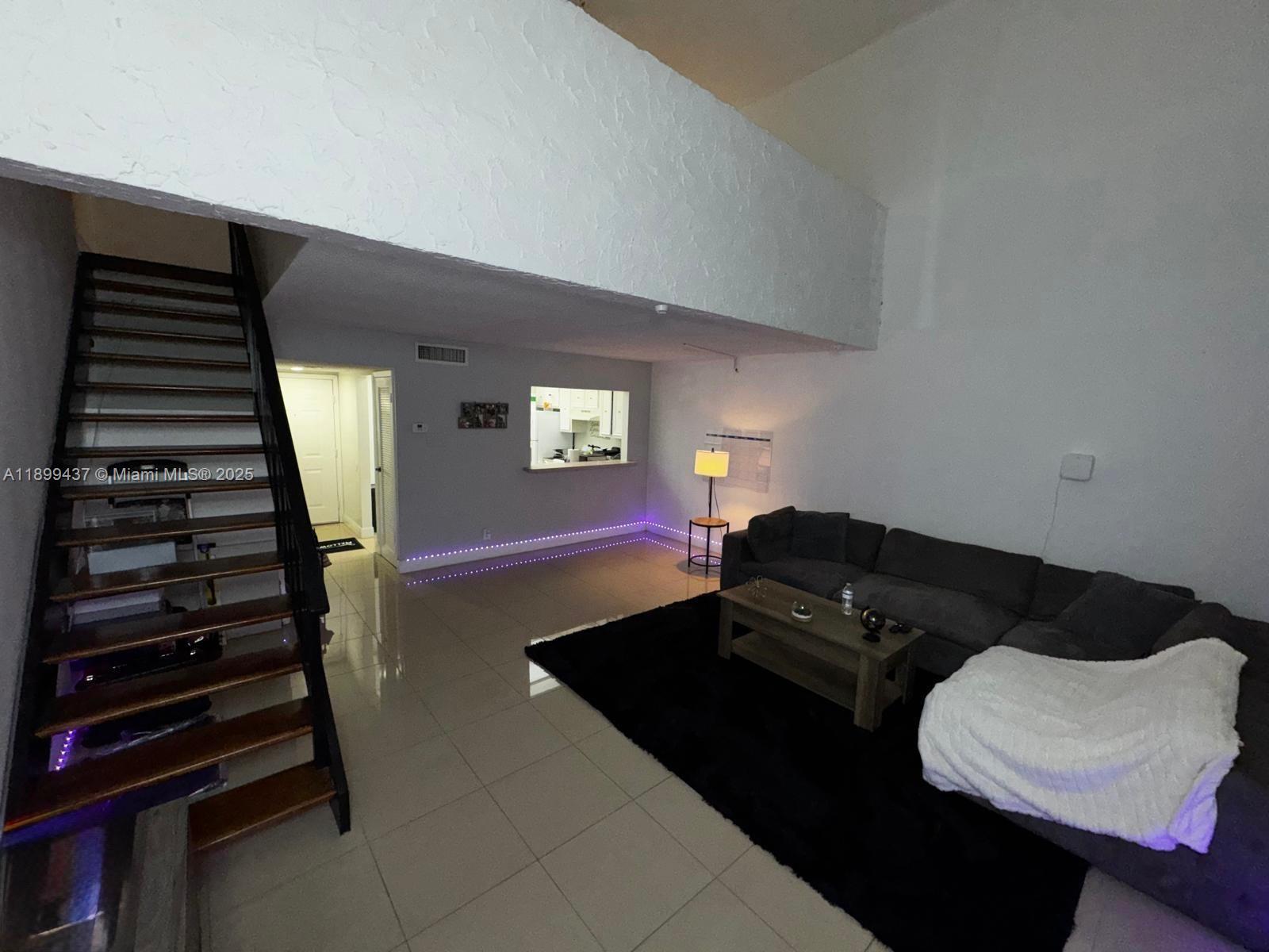 18111 Northwest 68th Avenue, Unit F203 Hialeah, FL 33015 - Photo 8 of 15 a living room with furniture and a window