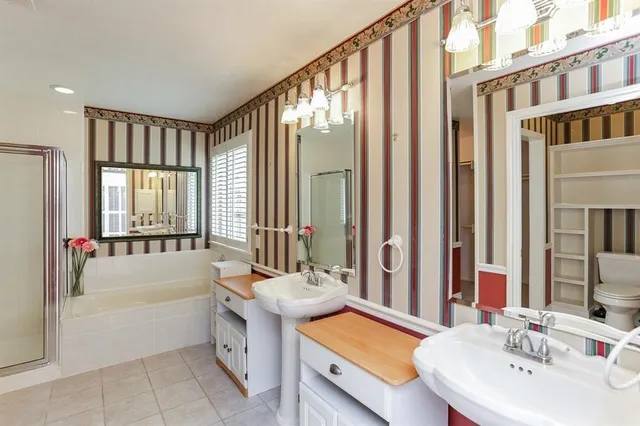 a bathroom with a tub a sink and a large mirror