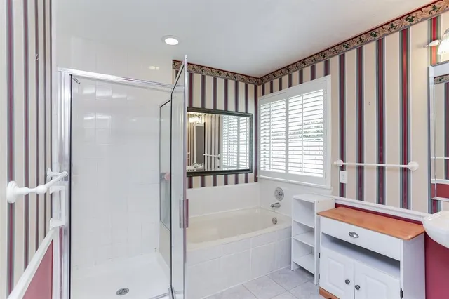 a bathroom with a bathtub a shower and a sink