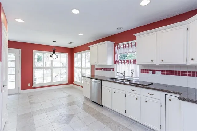 a large kitchen with stainless steel appliances a sink and cabinets