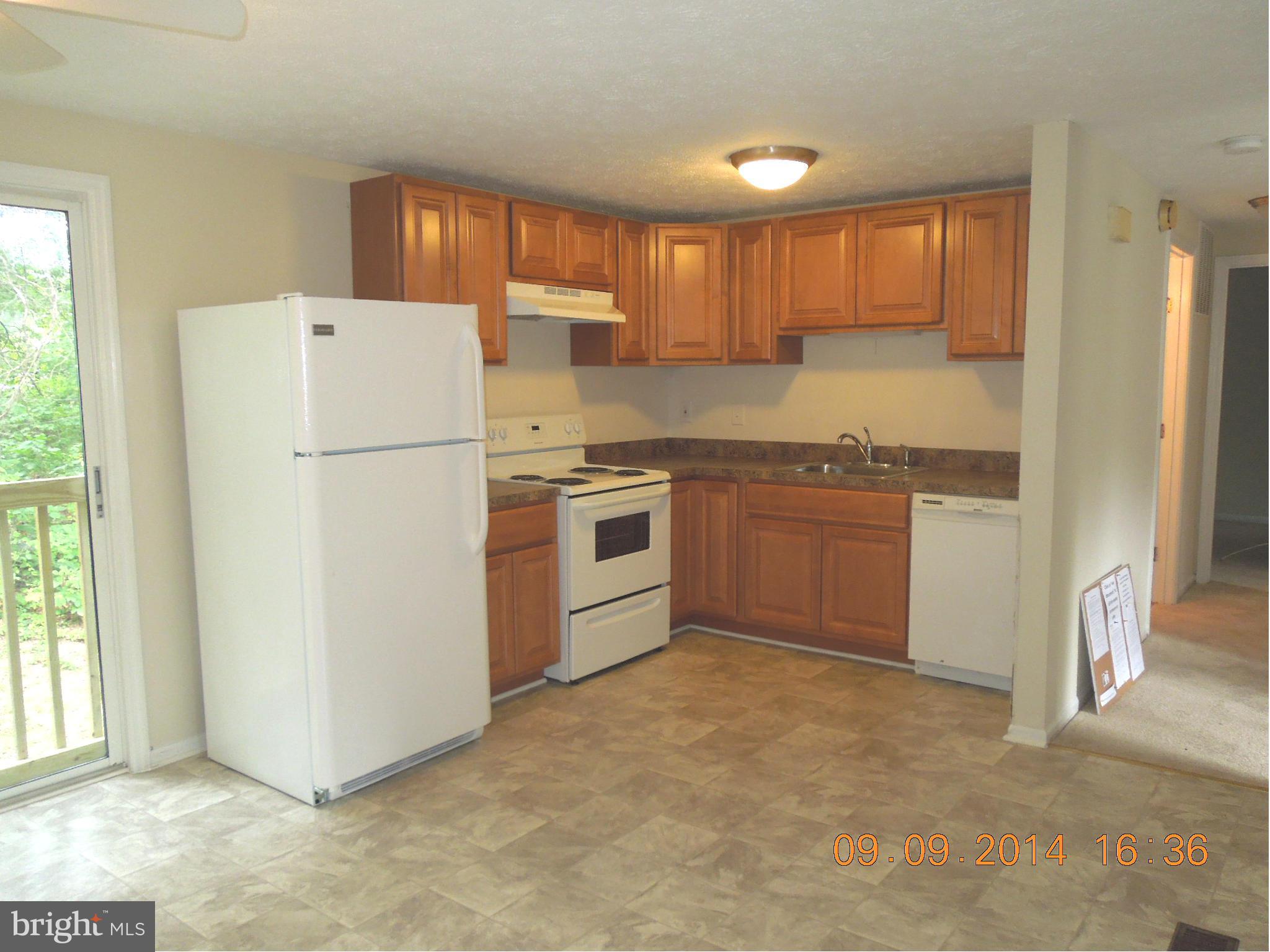 7030 Johnnycake Road Baltimore, MD 21228 - Photo 2 of 22 a kitchen with a refrigerator sink stove and cabinets