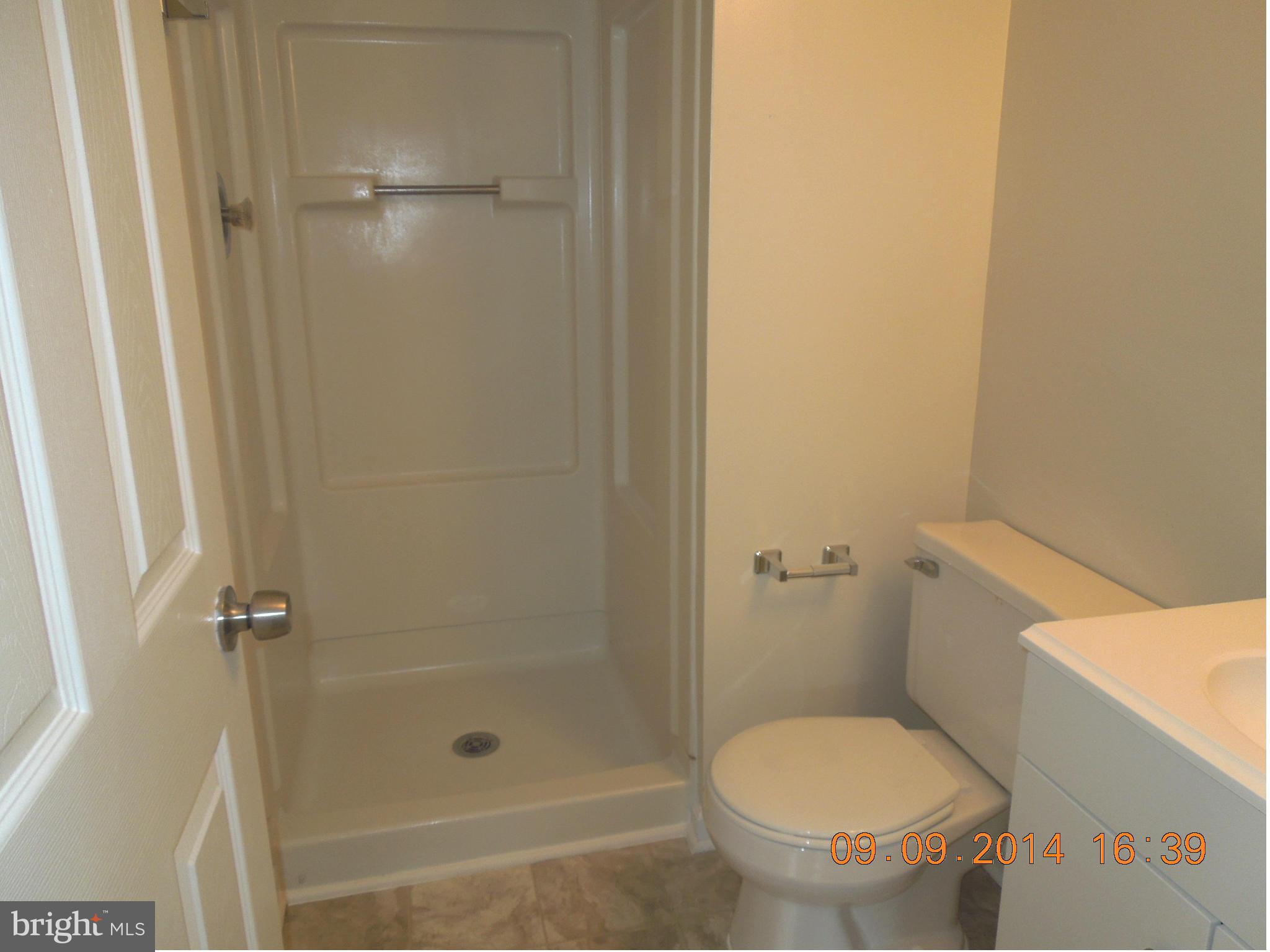 7030 Johnnycake Road Baltimore, MD 21228 - Photo 12 of 22 a bathroom with a granite countertop toilet and a shower