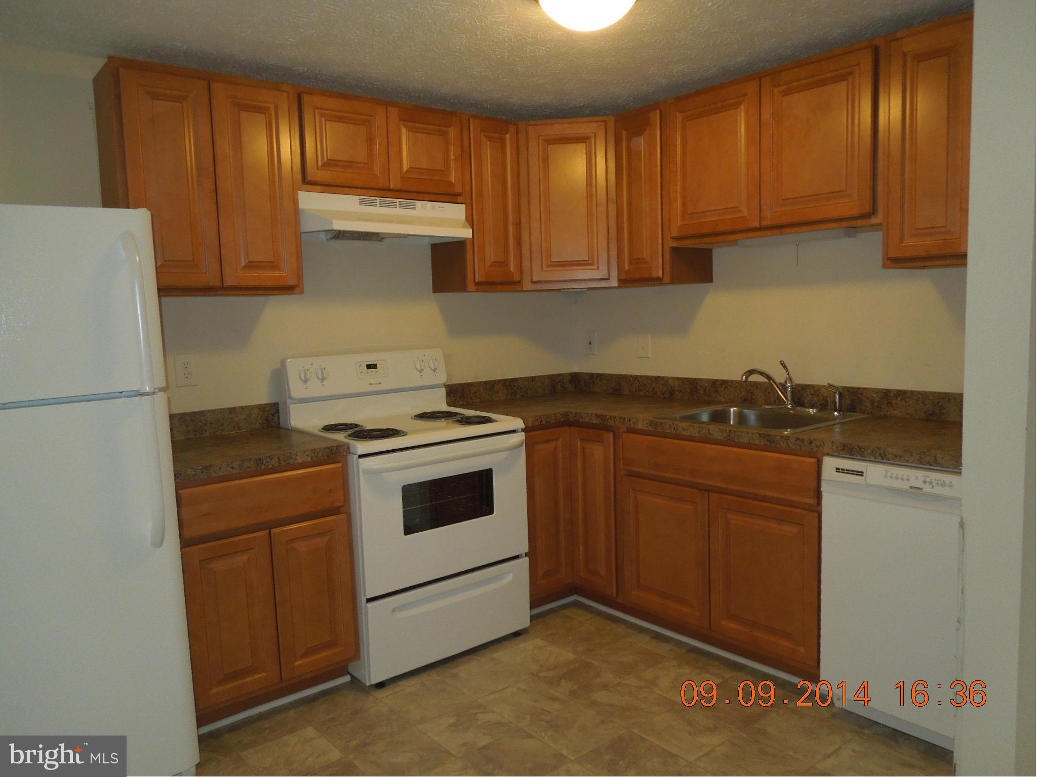 7030 Johnnycake Road Baltimore, MD 21228 - Photo 3 of 22 a kitchen with a stove sink and cabinets