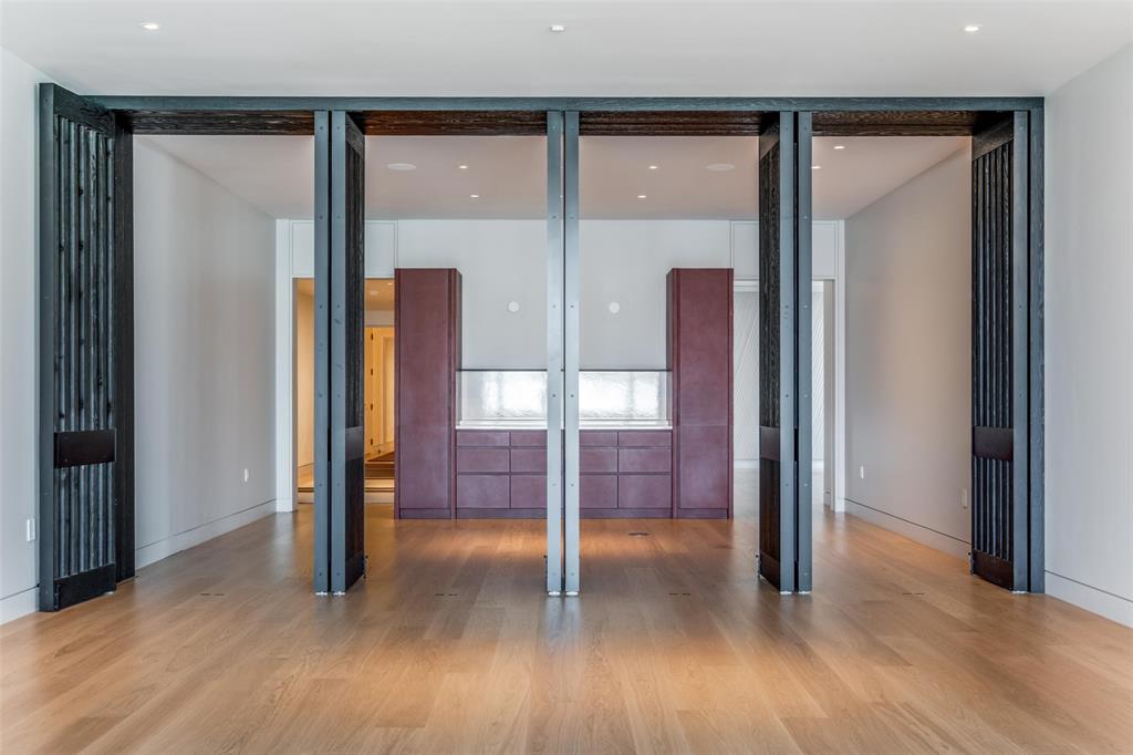 1747 Leonard Street, Unit 403 Dallas, TX 75201 - Photo 16 of 33 a view of a hallway with wooden floor and glass door