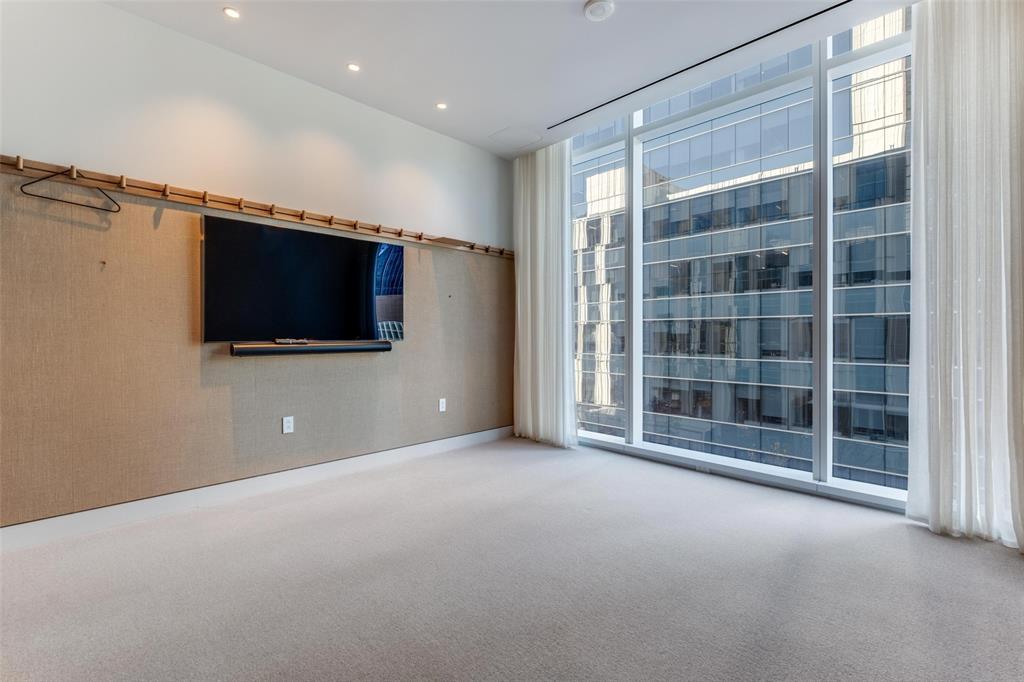 1747 Leonard Street, Unit 403 Dallas, TX 75201 - Photo 20 of 33 a view of an empty room with a flat screen tv and windows