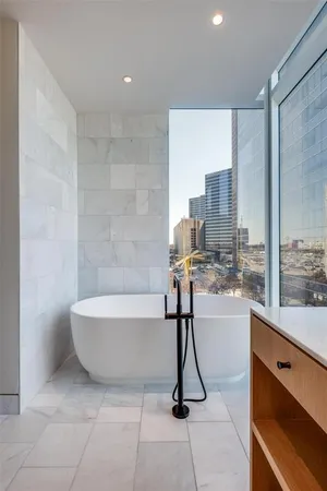 a bathroom with a granite countertop sink mirror and a bathtub