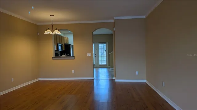 a view of a room with wooden floor and chandelier