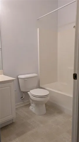 a white toilet sitting next to a bath tub