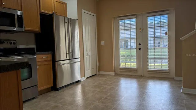 a kitchen with stainless steel appliances granite countertop a refrigerator microwave and stove