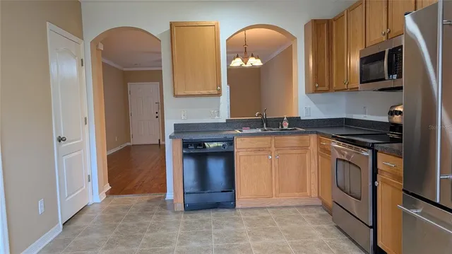 a kitchen with stainless steel appliances granite countertop a stove a sink and a microwave