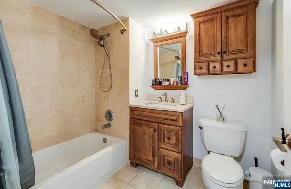 a bathroom with a toilet sink vanity tub and shower
