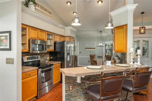 a kitchen with a table chairs stove and refrigerator