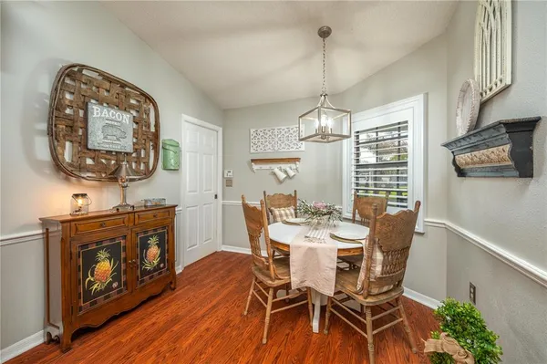 a view of a dining room with furniture a chandelier and wooden floor