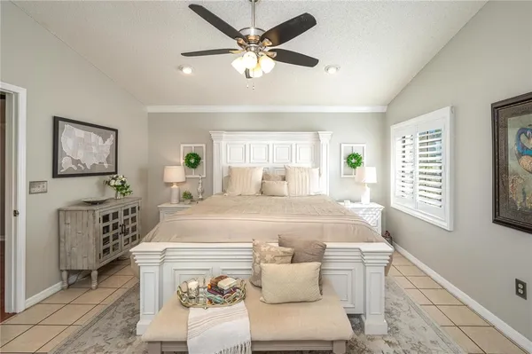 a spacious bedroom with a bed a window and dresser