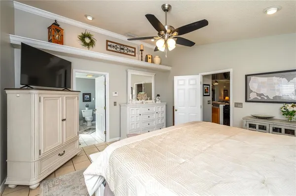 a spacious bedroom with a bed and a flat screen tv