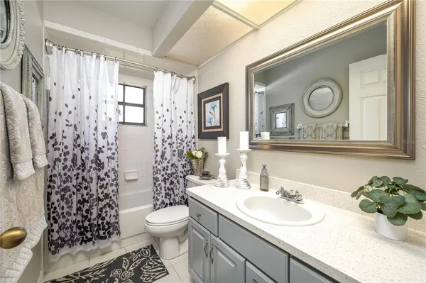 a bathroom with a granite countertop toilet sink and mirror